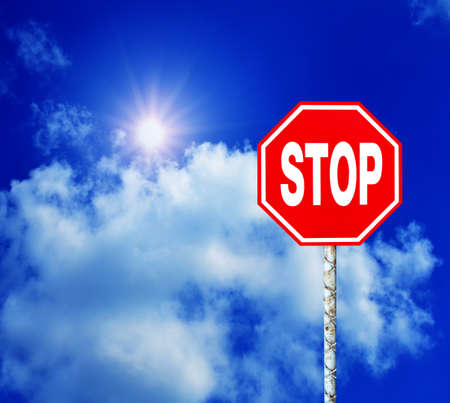 Red Stop Sign with Blue Sky and Clouds Backgroundの写真素材