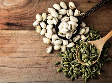 pistachio and pumpkin seed on vintage wooden boards still life
