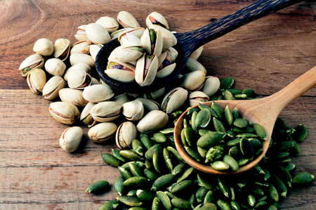 pistachio and pumpkin seed on vintage wooden boards still life