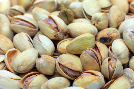 Lots of fried pistachios . On a white background in the plate is a lot of cooked pistachios as the background.の写真素材