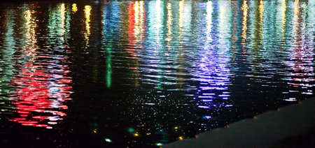 the reflection of the night in the city. Colored lights and high-rise buildings are reflected in the...