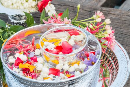 Water in bowl mixed with perfume and flowers, Songkran festival in Thailand.の写真素材