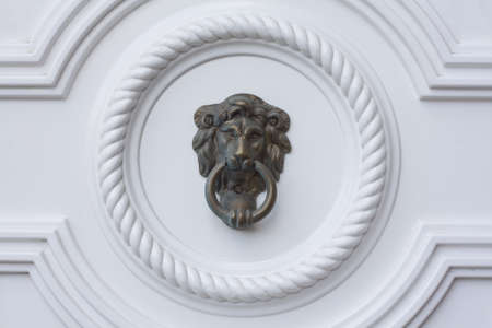Lion head door knocker on the white door の写真素材