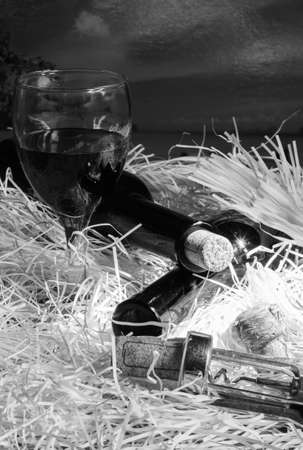 Glasses of red wine with bottle on fiber paperの写真素材