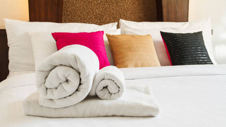 Roll towels on white bedの写真素材