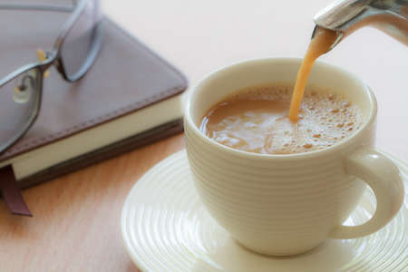 Pouring coffee in to cup on the morningの写真素材