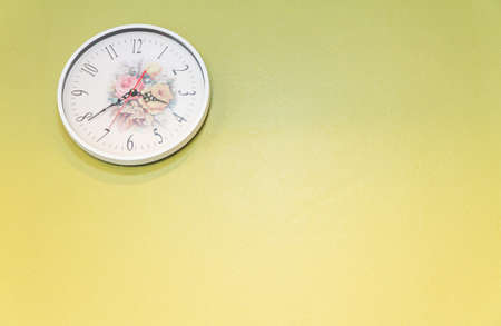 White clock on the yellow wall