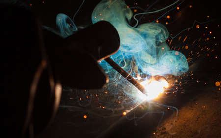Arc welding and welding fumes at the factory welding closeup.