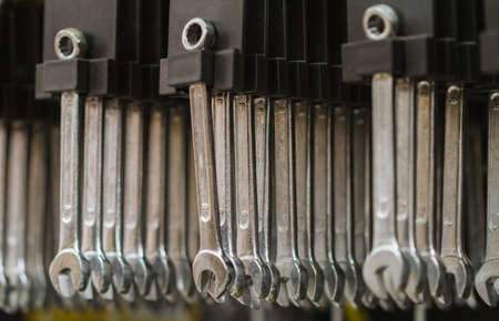 Set of wrenches hanging on shelf.