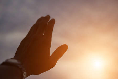 A hand with the sunset at the backgroundの写真素材