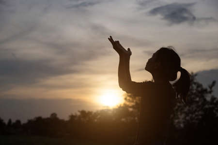 Believe. Girl praying to the sun.の写真素材