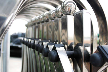 Chrome polished metal folding fence entrance. Safety concept, folding wall or boundary or folding gate on square tile, Shallow focus. Close up. Vintage effect.の写真素材