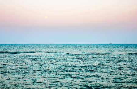 Beautiful sunset over the ocean, Calm Ocean And Blue Clear Sky Seascape Backgroundの写真素材