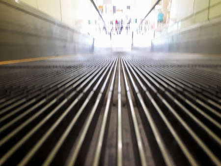 around the escalator motion blurred, Looking along an ascending escalator, with objects around the...