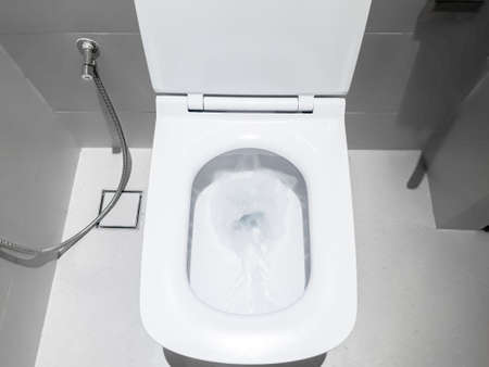 Toilet, Flushing Water, flush toilet, Closeup look at toilet, white toilet, White toilet in the bathroom, Top view of toilet bowlの写真素材