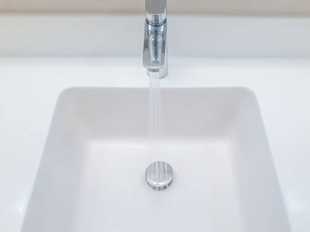 basin, wash basin close-up, basin and tap flowing , white wash basin close up, Detail of the basin, Bathroom sign toilet, working water tap, water flowing from the tap in the sink close-up, Water tap flowingの写真素材