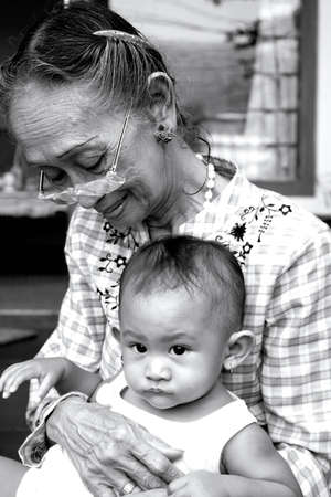 sweet moment of baby and grandma relaxing together. showing differences and resemblance in between:...