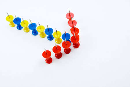 arrow formation of push pins, showing a guidance or directionの写真素材
