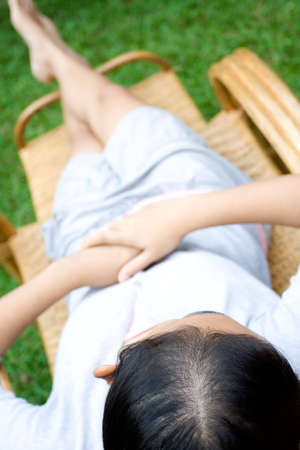 portrait of a woman relaxing on a bamboo lazy chair in the garden  の写真素材