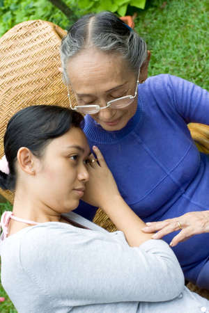 portrait of asian family: daughter feeling sad about her problem and lean her head on the shoulder...