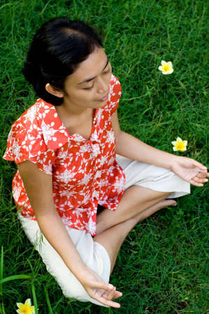 pretty asian young woman meditating in natureの写真素材