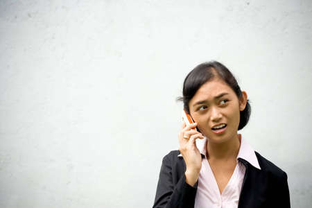 asian businesswoman having a serious conversation on the phone, perhaps persuating a client to seal...