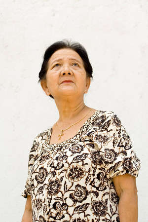 portrait of healthy asian elderly woman standing and looking up, being confident in facing the future. white backgroundの写真素材
