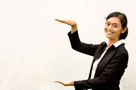 portrait of asian young woman raising hands showing a gapの写真素材