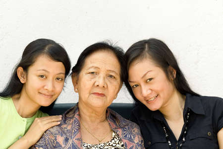 happy asian women generation of mother and two daughter posing togetherの写真素材