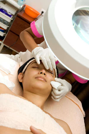 cleansing blackhead of a woman face during facial treatment