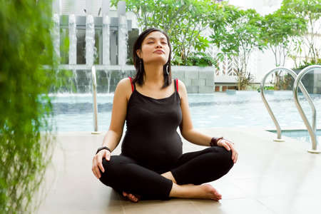 Active ethnic pregnant woman exercise breathingの写真素材