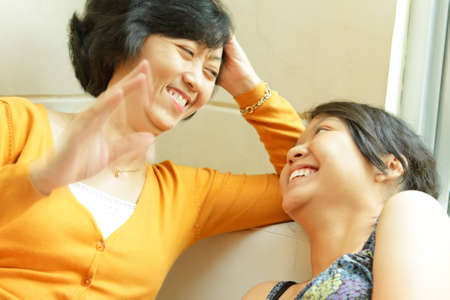 Asian ethnic mature mother enjoy conversation with teen daughterの写真素材