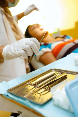female dentist with tools working on female patientの写真素材