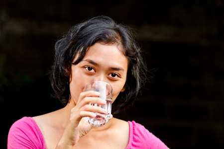asian ethnic young adult female in thirst drinking water