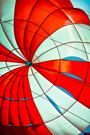 white and red parachute in the blue skyの写真素材