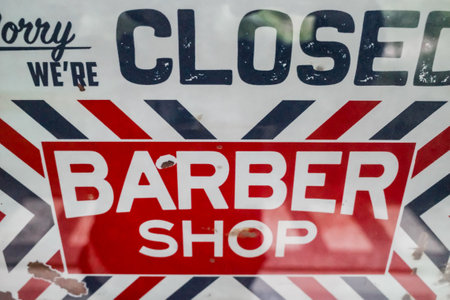 Red white navy sorry we`re closed door sign hanging on a barber shop front glass doorの写真素材