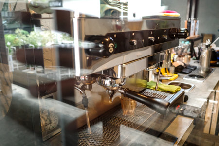 A Picture of a Coffee Making Machine Inside a Coffee Shop Taken from Outside the Window with Some Reflection of Outside Sceneの写真素材