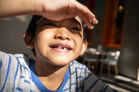 Asian little boy smiling showing that he has just had his milk tooth extracted