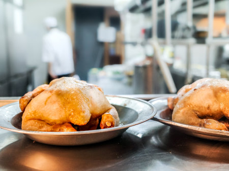 Chicken meat menu prepared in the kitchen of a restaurant with chef and staff working in the backgroundの写真素材
