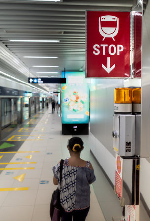 Train stop sign placed near the emergency panel at city subway station