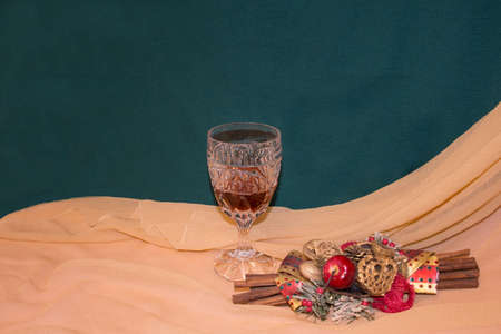 The celebration can begin with a beautiful wine in a crystal glass and fragrant cinnamon trees, with a background that gives a celebratory impression by combining the green and beige color of the canvasの写真素材