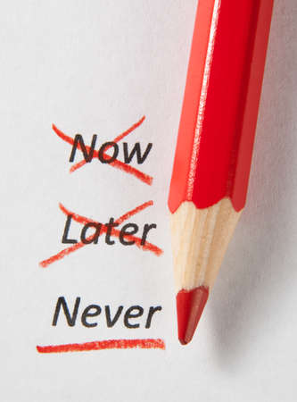 Never not now and later checked by red pencilの写真素材