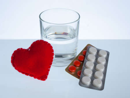 Heart, glass of water and blister packs of pillsの写真素材