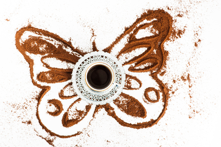 Cup of coffee and ground coffee butterfly shapeの写真素材