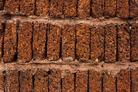 Red-brown laterite brick wall backgroundの写真素材