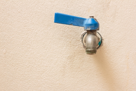 blue old faucet on pink wallの写真素材