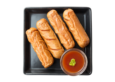 Fried sausage in black dish isolated on white background