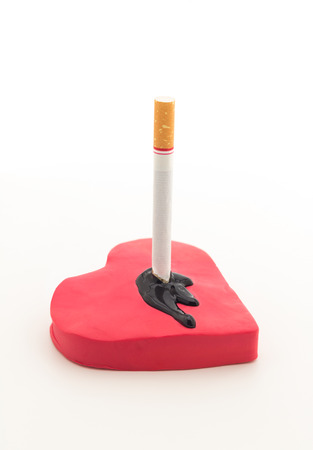 Cigarette in red heart and black blood on white background , danger from cigarettes conceptの写真素材
