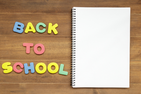 text back to school with open blank page notebook on brown wooden backgroundの写真素材