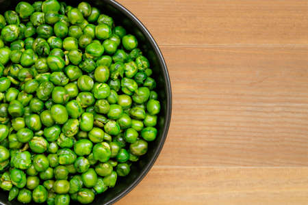 close up of roasted green peas in black bowlの写真素材